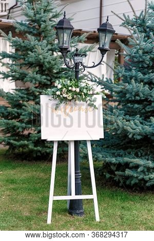 Wedding White Board Mockup Easel With Welcome Sign Decorataed With Flowers, Outdoors. Greeting Card 
