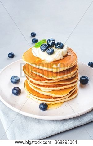 A Stack Of Pancakes With Fresh Blueberries And Cheesecream.