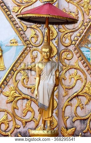 Vertical Image Statue Of Gold  Buddha Leela Standing With Stucco Laos Style On The Wall