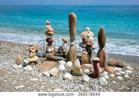 Concept of zen balance relaxation peace and harmony. Pebbles stacks on the beach coast of the blue sea in the nature. Meditative art of stone stacking.