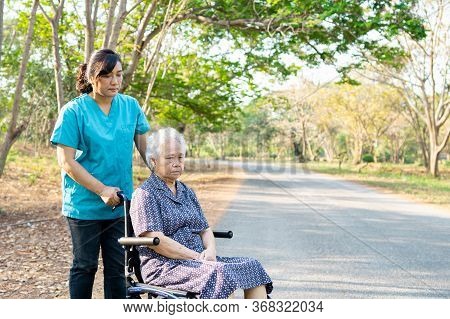 Nurse Help And Care Asian Senior Or Elderly Old Lady Woman Patient Sitting On Wheelchair At Park In 