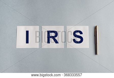 Irs Acronym Text Written On White Papers Notes And Golden Pen On Blue Table. Tax Reminder. Revenue S