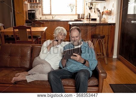 Happy Active Senior Man And Woman Video Calling Family Using Digital Tablet. Couple Enjoying Togethe