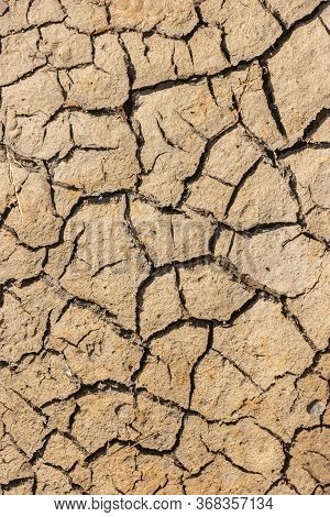 Part Of A Huge Area Dried Land Suffering From Drought - In Cracks. Dry Water Reservoir. Natural Drou