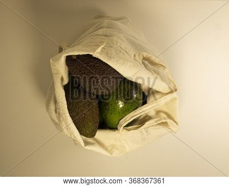 Different Varieties Of Avocado Ripen In A Light Canvas Bag On A White Background. Top View