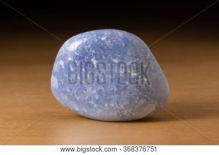 Polished Dumortierite Quartz Gemstone From Portugal Over A Wooden Table