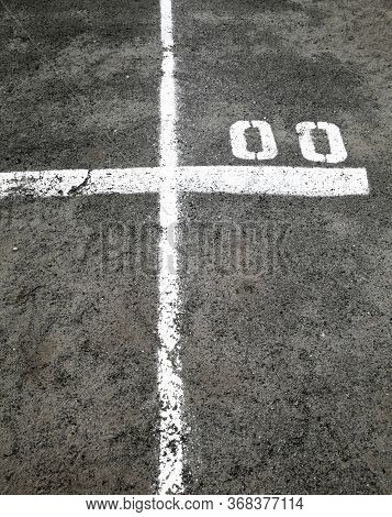 White Marking Lines And Numbers On The Asphalt Surface.