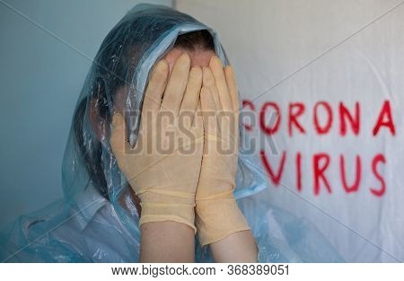 Woman In A Protective Suit Closing Her Face. Inscription Coronavirus In The Background. Coronavirus 