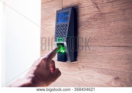 Man Push Finger Down On The Electronic Control Machine To Access The Door.