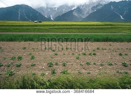 Farmer Fertilizing Fields With Tractor In The Austrian Alps, Mieminger Plateau Before Rain, Tyrol, A