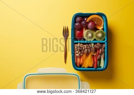 Top View of Full Lunch Box with Fuits, Vegetables and nuts.