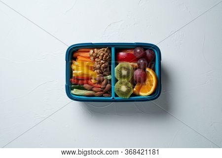 Top View of Full Lunch Box with Fuits, Vegetables and nuts.