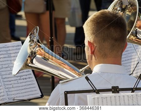 Moscov, Russia - Aug 12, 2017: Sunlighted Young Adult Tuba Player And His Distorted Reflections In T