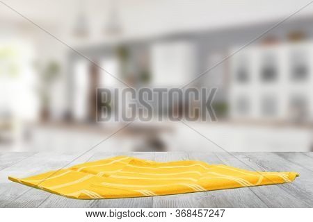 Closeup Of A Empty Yellow Striped Tablecloth Or Napkin On A Bright Rustic Wooden Table Against Abstr