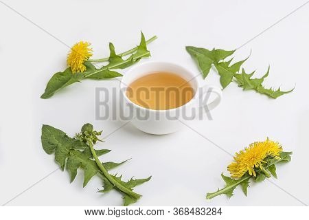 Cup Of Purifying, Diuretic Tea Of Dandelion With Fresh Leaves And Flowers On A White Background. Fre