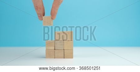 Close Up At Wood Cube Arrange In Pyramid Shape, Business Concept Mock Up.