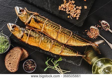 Appetizing Smoked Fishes With Sawdust And Burlap Texture On Slate Stone Background. Mediterranean Fo