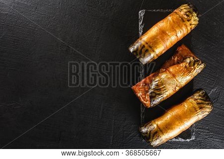 Appetizing Smoked Mackerel Fish Rolls With Spices, Pepper And Bread On Dark Slate Background. Medite