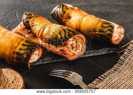 Appetizing Smoked Mackerel Fish Rolls With Spices, Pepper And Bread On Dark Slate Background. Medite