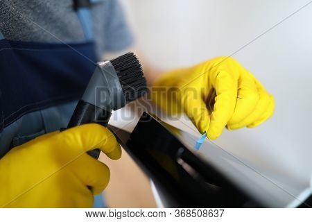 Close-up Of Male Worker Cleaning Cookstove With Vacuum Cleaner And Taking Off Protective Film. Man W
