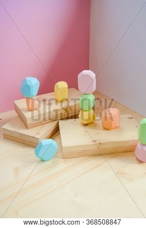 Abstract Figures From Elements Of Wooden Tumi Ishi Pastel Colors On A Wooden Podium On A Paper Backg