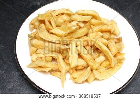 A Plate Of Deep Fried Potato Chips From An English Fish And Chips Shop
