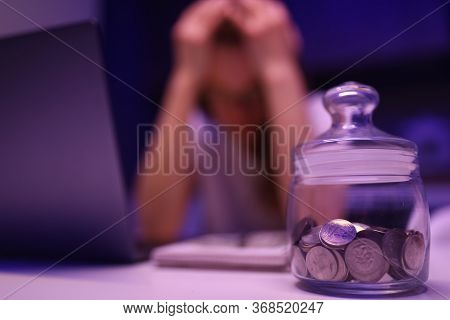 Close-up Of Glass Container With Coins. Depressed Woman Calculating Family Financial Situation. Pers