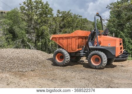 An Orange Dumper On A Road Construction Site