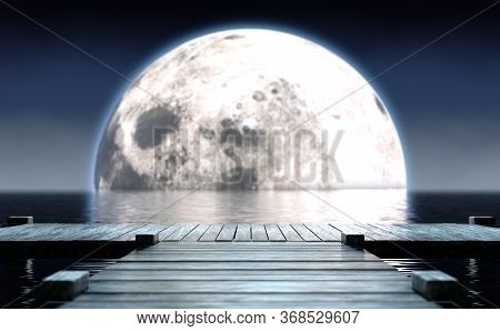 A Wooden Boat Jetty Jutting Out Across Calm Water With A Full Moon Rising On The Horizon At Night - 