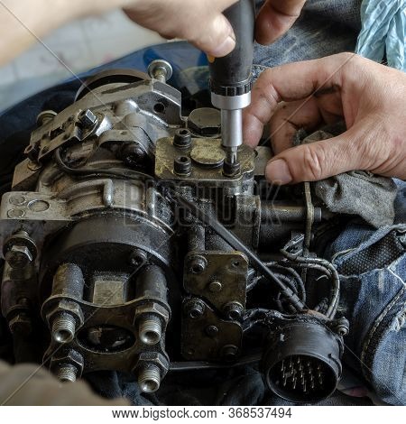 A Mechanic Disassembles And Detects A Fuel Injection Pump. The Process Of Repairing The Fuel Pump Of
