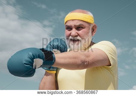 Best Cardio Workout. Elderly Man Hitting Punching Bag. Healthy Fighter Senior Old Man Boxing Gloves.