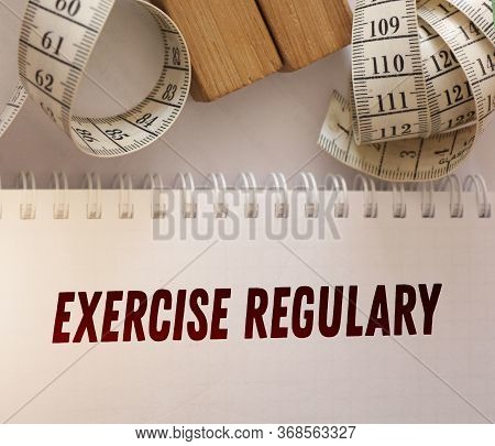 Measurement Tape And Exercise Regulary Words On The Page Of Copybook. Fitness Traning, Regular Exerc