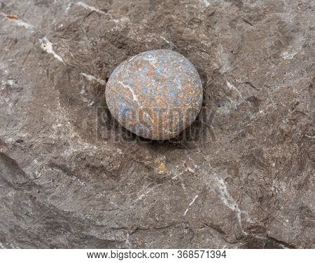Round Stone - A Large Sea Pebble Lies In A Recess Of The Rock
