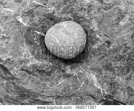Round Stone - A Large Sea Pebble Lies In A Recess Of The Rock