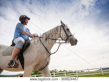 Dubky, Ukraine - May 23, 2020: Teen Girl In Helmet Learning Horseback Riding In Dubky