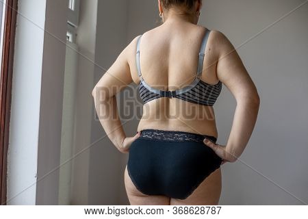 Woman Real Body Plus size model in lingerie posign and showing fat on back, imperfect nonideal