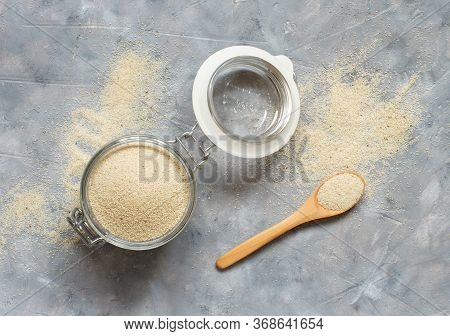 Raw Uncooked Fonio Seeds In A Glass Jar With A Spoon Top View