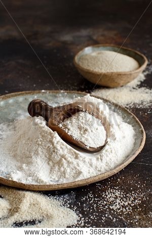 Raw Fonio Flour And Seeds With A Spoon On Dark Background Close Up. Alternative Flour