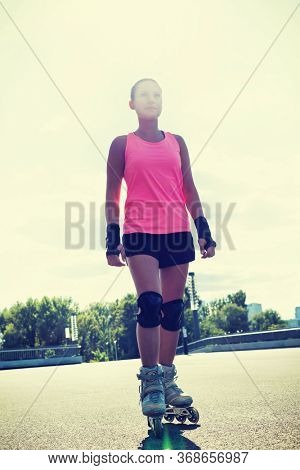 Portrait of young attractive woman wearing rollerblades