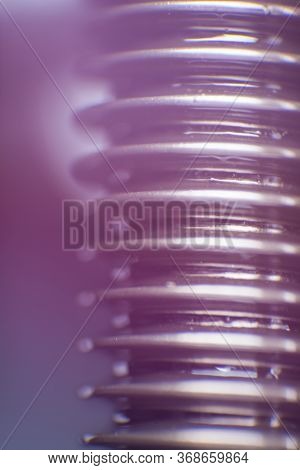 Close-up Of A Screw Bolt In Lilac And Purple On A Dark Background. Bright Stylish Wallpaper For The 
