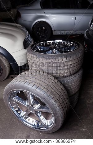 A Set Of Stylish Tuned Wheels With Shiny Chrome Disks Folded Into The Composition Against The Backgr