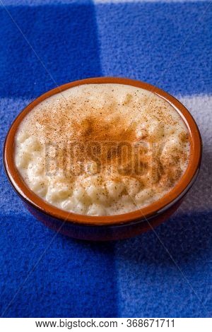 White Corn Cooked With Milk Known As Canjica, Canjicão Or Mungunza, In A Rustic Bowl On Wooden Table