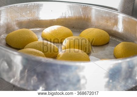 Molding Yellow Dough Into Corn Bread Over Black Table With Some Flour. Flat Lay Of Homemade Healthy