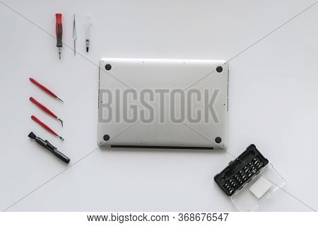 A Top View Of The Computer Master In The Service Fixing The Laptop Computer On White Table