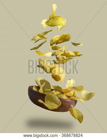 Crispy Potato Chips Falling Into Clay Piala, Close-up, Isolated Background