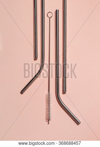 A Set Of Reusable Cocktail Tubes And Cleaning Brushes On A Pink Background. The Concept Of Zero Wast