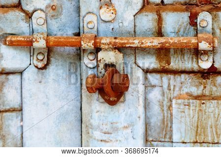 A Weathered Door Locked By Nut And Bolt
