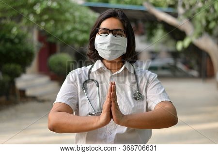 Portrait Of A Young Medical Healthcare Female Worker With Hands Crossed / Folded In Namaste, Wearing