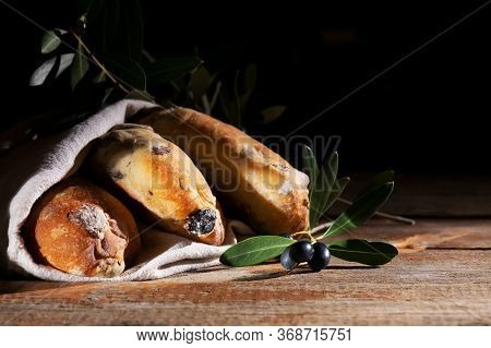 Traditional Italian Puccia Breads With Black Olives In A Cotton Bag, Made In Salento, Puglia On A Wo