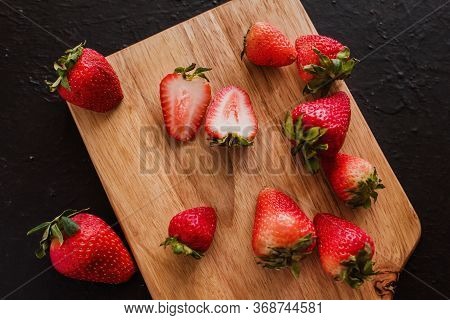 Strawberries On A Wooden Table In A Black Background